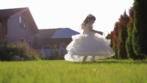 Niña en vestido blanco bailando en la hierba de cámara lenta — Vídeos de Stock