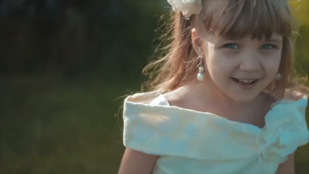 Klein meisje in de witte lacht om Camera — Stockvideo