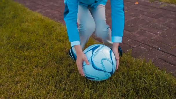 Αγόρι παίζει με μια μπάλα στο γκαζόν κοντά στο σπίτι — Αρχείο Βίντεο