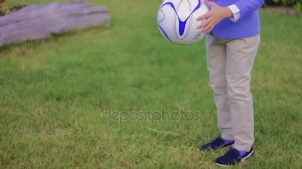 Menino em jaqueta joga com a bola — Vídeo de Stock