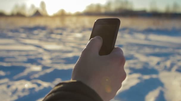 El hombre usa el teléfono en el frío — Vídeo de stock