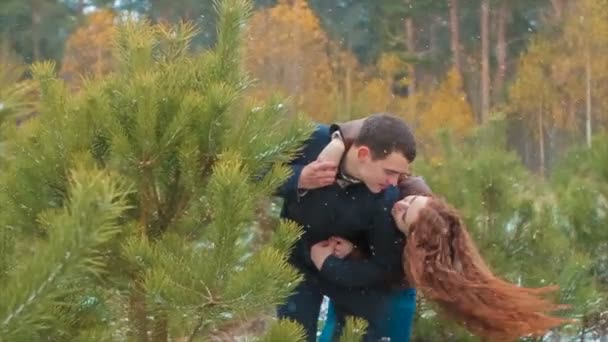 Divertido casal jovem na neve perto de pinheiros jovens — Vídeo de Stock