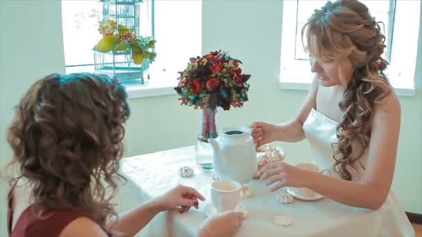 İki genç kız aydınlık salonda çay içiyorlar — Stok video