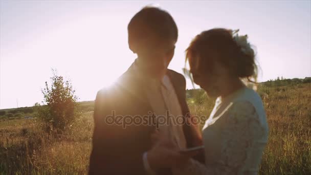 Νύφη και το γαμπρό στο Smartphone χρησιμοποιώντας το ηλιοβασίλεμα — Αρχείο Βίντεο