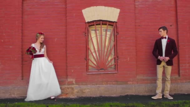 Sposa e sposo incontrato in strada vicino muro di mattoni — Video Stock