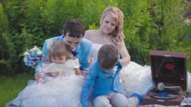 Gelin ve damat çocuklarıyla birlikte piknik. Ağır çekim