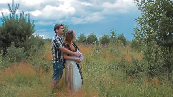 Mąż i żona w ciąży cieszyć się Pogoda w dziedzinie zwolnionym tempie — Wideo stockowe