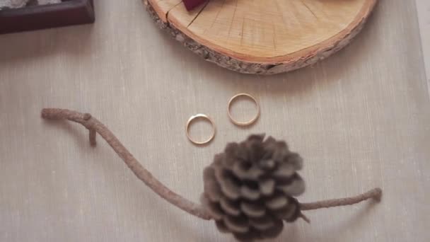 Sobre la mesa entre los adornos Lie anillos de boda en cámara lenta — Vídeos de Stock