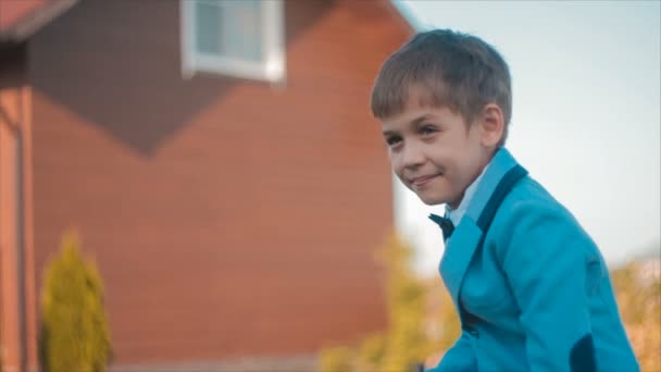 Мальчик в костюме стоит с мячом медленное движение — стоковое видео