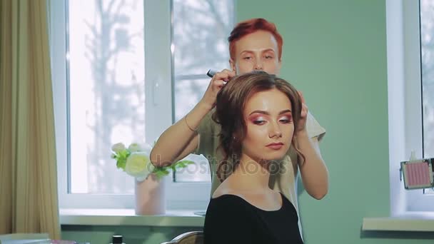 Перукар робить зачіску для дівчини в домашніх умовах — стокове відео
