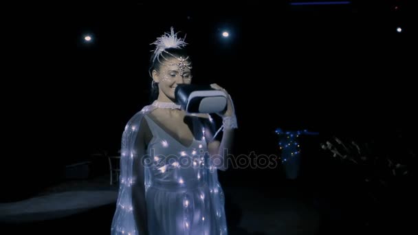 Brunette vrouw virtuele hoofdtelefoon dragen in kostuums van witte LED 's — Stockvideo