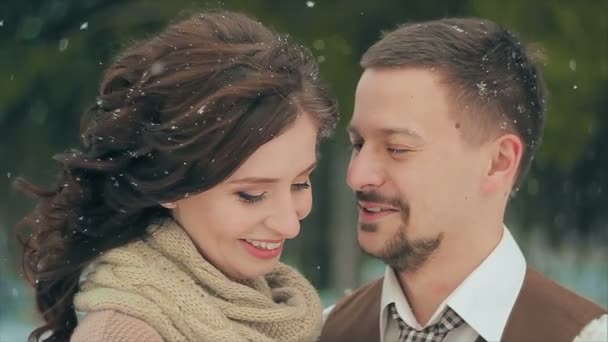 Novomanželé s úsměvem při sněžení na zimní den. — Stock video