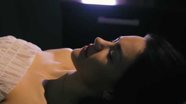 Brünette Frau liegt auf Massagetisch im Schönheitssalon in Nahaufnahme — Stockvideo