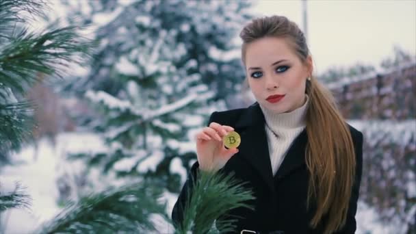 Όμορφη νεαρή κοπέλα επιτυχημένη χρυσή bitcoin κρατά στα χέρια — Αρχείο Βίντεο