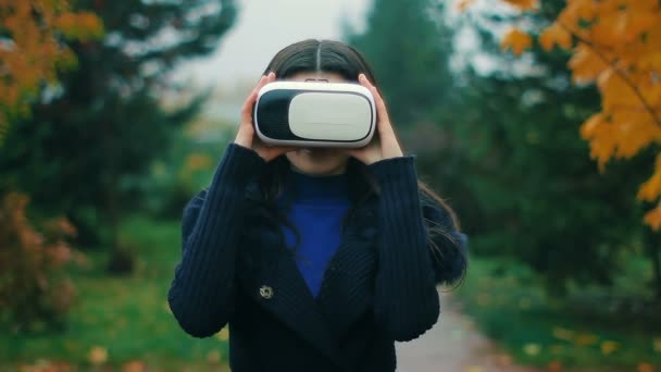 Morena testando mais recente realidade de aumento produzindo equipamento VR fone de ouvido usando suas mãos — Vídeo de Stock