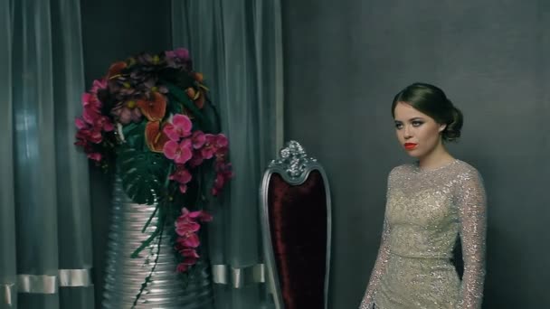 Modelo menina em vestido branco posando para câmera perto de flores — Vídeo de Stock