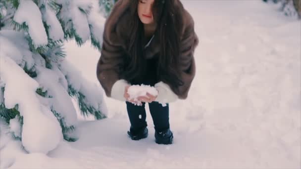 Μελαχρινή γυναίκα που ρίχνουν το χιόνι σε αέρα σε χειμερινές διακοπές σε αργή κίνηση — Αρχείο Βίντεο
