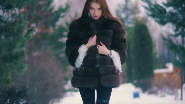 Brunette rijke vrouw taille vacht van bruin bont op achtergrond van kerstboom slow motion — Stockvideo