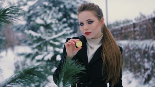 Menina segura bitcoin em mãos parque de inverno câmera lenta — Vídeo de Stock