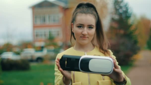 Μελαχρινή νεαρή γυναίκα σε κίτρινο δοκιμή σετ κεφαλής εικονικής πραγματικότητας — Αρχείο Βίντεο
