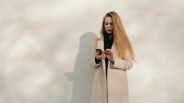 Mulher olhando como Nicole Kidman com telefone compra on-line ao ar livre — Vídeo de Stock