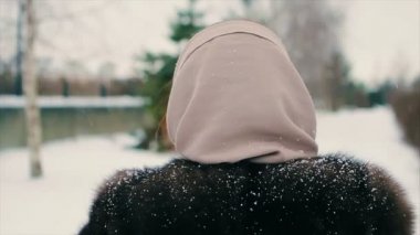 Noel ağacı ağır çekim arasında kar parkta yürüyen esmer kadın