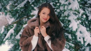 Esmer zengin kadın bel kat Noel ağacı yavaş arka plan üzerinde kahverengi kürklü