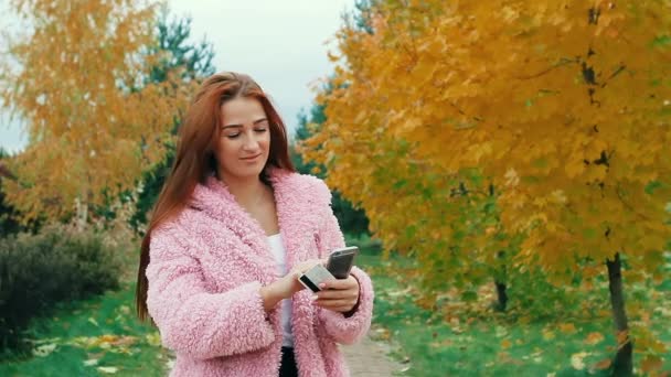 Portrait of happy redhead woman buying online with smart phone outdoors — Stock Video