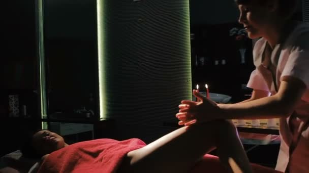 Brünette Frau liegt auf Massagetisch im Schönheitssalon, während professioneller Therapeut Magenmassage macht — Stockvideo