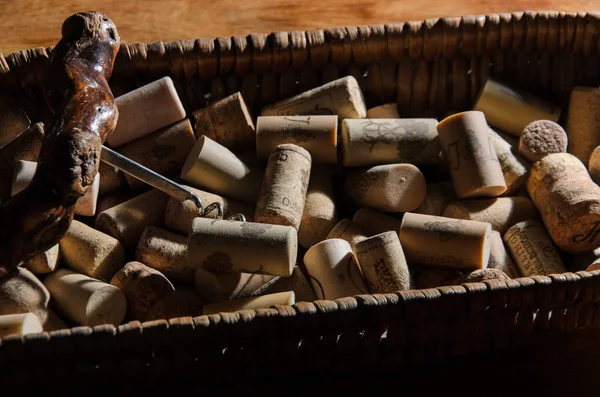 Corchos de vino en una canasta vieja pan en madera de palisandro —  Fotos de Stock