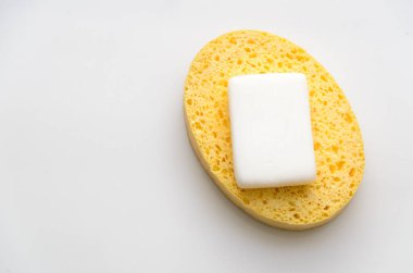 c beyaz bir zemin üzerine yerleştirilmiş bir sarı sünger üzerinde kullanılan sabun