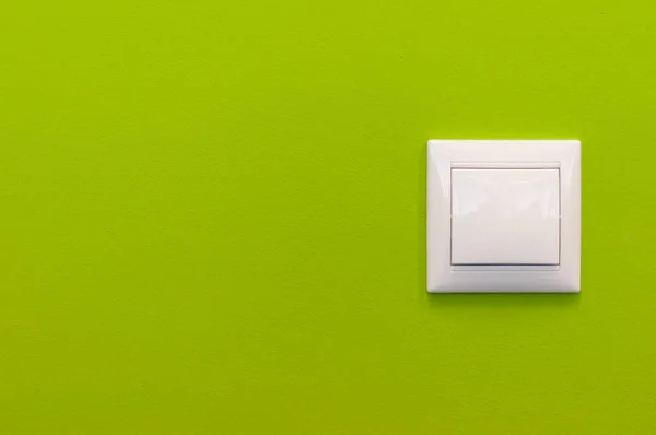 Світло вмикається на зеленій стіні з декоративною штукатуркою. Яскрава спина Стокове Фото
