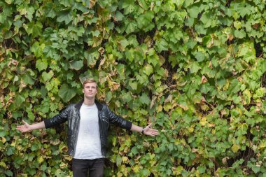 çiçekli bir duvara genç adam