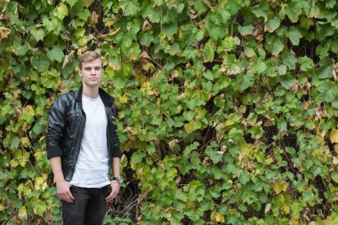 çiçekli bir duvara genç adam