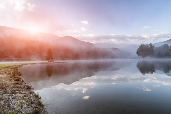 Salida del sol de verano en el lago Moutnains, nubes de colores y reflexión — Foto de Stock