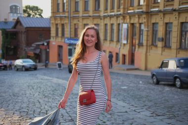 Güzel, genç bir kız açık havada poz elbise ve kot pantolon ceket