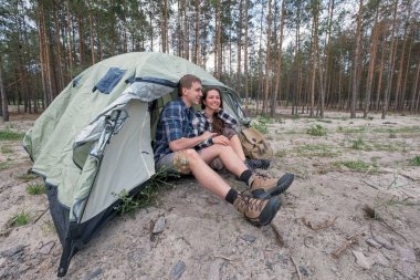 Mutlu sevgi dolu çift yakınındaki ormanda çadır dinlenme