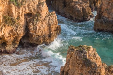 güzel Atlantik Okyanusu görünümü ufuk ile kumlu plaj, kayalar ve güneş doğarken dalgalar. Algarve, Portekiz