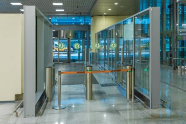 Havaalanı ya da tren istasyonunun kapalı kapısı. Tahliyeden sonra iş merkezinin cam ve çeliğiyle modern iç mekan, kancayı kirletiyor ya da terk ediyor ya da hafta sonu