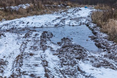Kötü zemin ya da toprak kırsal ya da banliyö yolu ya da su birikintileri, havuzlar, çamur ve çamur ile dolu yollar.