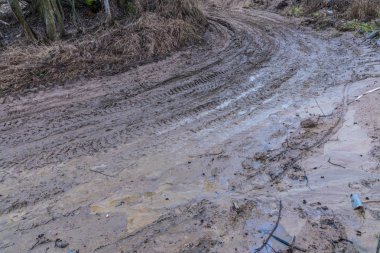 Kötü zemin ya da toprak kırsal ya da banliyö yolu ya da su birikintileri, havuzlar, çamur ve çamur ile dolu yollar.