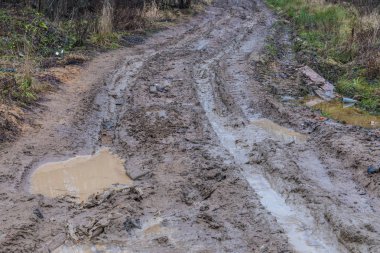 Kötü zemin ya da toprak kırsal ya da banliyö yolu ya da su birikintileri, havuzlar, çamur ve çamur ile dolu yollar.