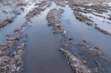 Kötü zemin ya da toprak kırsal ya da banliyö kış yolu ya da buz, kar, su birikintileri, havuzlar, çamur ve sulu kar