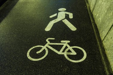 Beyaz bisiklet ve erkek sembolleri ıslak ya da nemli asfaltta.