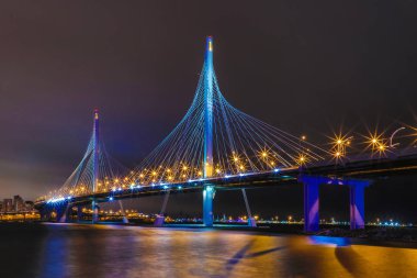 Neva Nehri 'nin üzerindeki çevre yolu köprüsü gece ağzının yanında. Petersburg ve Bitiş Körfezi 'ndeki binaların gece görüşü