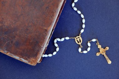 Altın haç ve eski İncil'de mavi bir arka plana dayanır