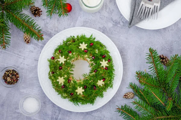 Sebzeli Olivier salatası Noel çelengi, et (sosis), yumurta ve mayonez gri arka planda. Yılbaşı ve Yeni Yıl için geleneksel Rus ve Ukrayna salatası.