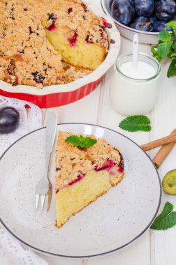 Beyaz ahşap arka planda bir tabakta erikli turta ve shtreisel. Kırsal tarzda. Ev yapımı pişirme..