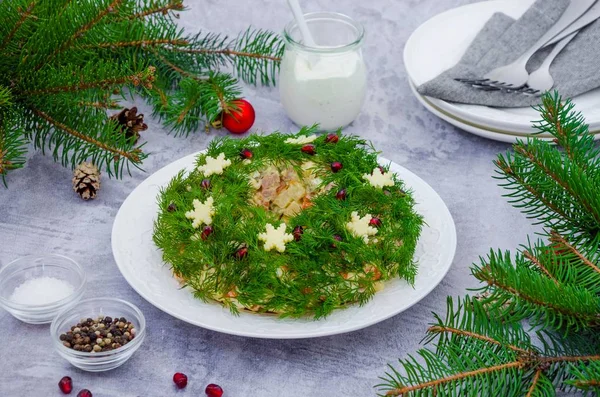 Оливье салат Рождественский венок с овощами, мясом, яйцами и майонезом на тарелке на сером фоне. Традиционный праздничный русский и украинский салат на Рождество и Новый год . — стоковое фото