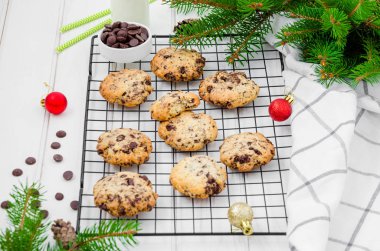 Beyaz ahşap arka planda metal bir askıda çikolata parçalı geleneksel Amerikan kurabiyeleri. Yeni yıl ve Noel için şenlikli bir tatlı. Kapat..